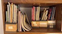 Shelf with three cardboard organizers holding assorted booklets and magazines