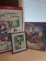 Group shot showing three of the four framed pieces including red-framed poster, Bergsma print, and Renoir print