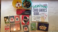 Lot overview showing card decks, UNO, checkers, chess pieces, dice and book