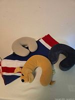 Three U-shaped pillows, dog-shaped pillow, Union Jack blanket visible