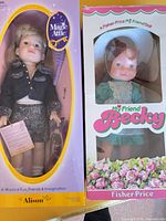 Front view of both boxed dolls showing packaging and contents