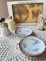 Overview showing boxed miniature tea set, two saucers, three figurines