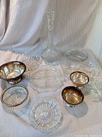 All items grouped: decanter, multiple glass bowls, silver-plated bowls, divided dish, candlesticks