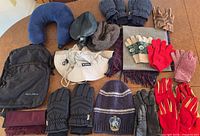 All items laid out: backpack, neck pillow, hats, scarves, multiple glove pairs