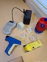 Full group showing label maker, pricing gun, sharpener, timer, discs, measuring cups