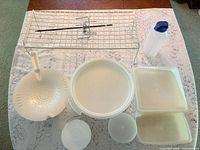 Group shot showing all storage pieces, colander, bottle, wire rack and spit