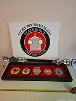 Lot overview with Rolls-Royce sign, shadowbox of badges, and loose emblems