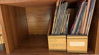 Two cardboard magazine holders filled with assorted catalogs and magazines