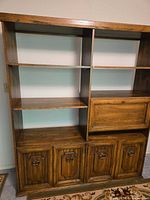 Front view showing full wall unit with shelves, drop-front desk closed and lower cabinet doors