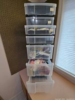 front view showing six clear drawers filled with craft supplies