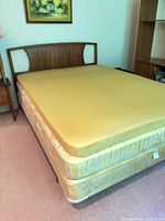 Bed assembled with mattress, foam topper, box spring, headboard, portion of frame