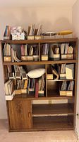 Front view showing full height bookcase with shelves and lower cabinet