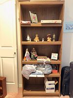 Front view of tall brown veneer bookshelf with five shelves