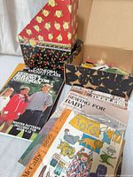 Overview of lot showing sewing booklets, pattern envelope and storage boxes