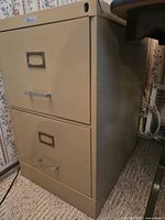 Front and side view of metal two-drawer beige file cabinet under desk