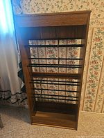 Full front view of media rack showing wood veneer frame and metal rod shelves