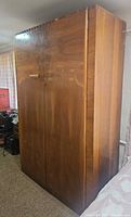 Front and left side view of tall wood veneer armoire wardrobe