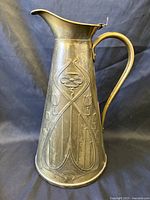 Left side view showing full pitcher, handle, lid and Art Nouveau motif