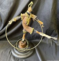 Front view of acrobat sculpture with hoops on wood base