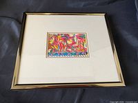Full view of framed artwork on dark fabric background