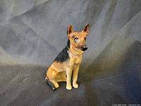 Front three-quarter view of the seated German Shepherd figurine