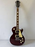 Full front view of burgundy Les Paul style guitar
