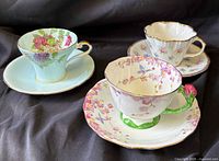 Three teacup and saucer sets grouped