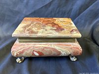 Front angled view of onyx box showing overall form and bronze feet