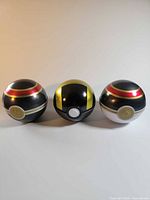 Front view of three Pokeball tins