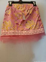 Front view of pink floral toddler tutu skirt on hanger