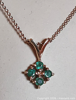 Close-up of emerald cluster pendant on chain