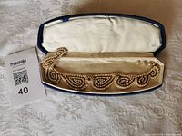 Necklace displayed inside open case with MaxSold lot card