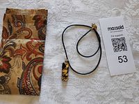 Full view of necklace, fabric pouch and lot card