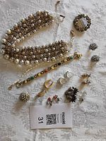 Overview of entire jewelry lot laid out on white cloth