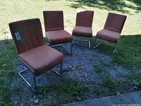 All four matching chrome framed chairs outdoors on gravel