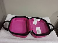 Bag open showing pink interior, black handles, zip edge