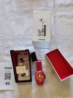 Watch, open box, display cushion, exterior box visible