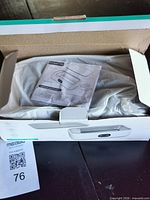 Box opened showing wrapped ultrasonic cleaner and instruction manual