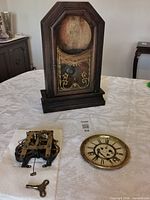 Overall view of wood case, movement, dial and key