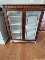 Full front view of Honderich cabinet showing twin glass doors and white interior shelves