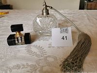 Both perfume bottles side by side with tassel visible