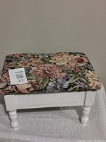Overall view of ottoman showing floral upholstered lid and white base