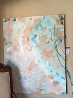 Front view of large abstract canvas leaning against wall