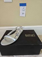Side view of one sandal resting on branded box