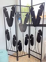 Full view of 3-panel black metal room divider with leaf motif