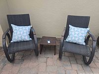 Pair of wicker rocking chairs, side table, pillows