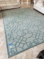 Full view of light blue aqua geometric rug placed on tiled floor