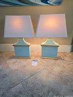 Both lamps side by side illuminated showing overall design and dimensions card