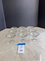 Eight of the clear glass dessert cups arranged on surface