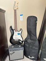 Full view of guitar, amplifier, and gig bag together
